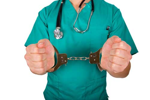 A doctor in handcuffs, being charged with Medical Malpractice. 