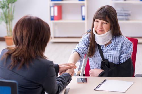A woman meeting with a Dunwoody personal injury lawyer after suffering a neck and arm injury.