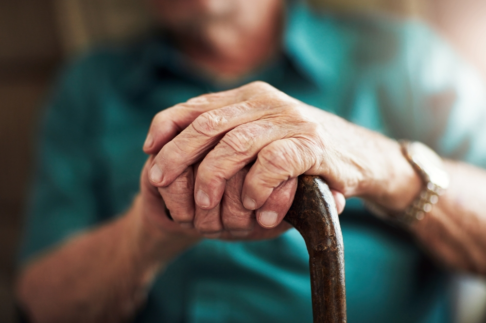 Close-up of an elderly person holding a cane, symbolizing vulnerability in wrongful death cases in Atlanta.