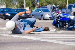 Motorcycle rider falling off bike at intersection