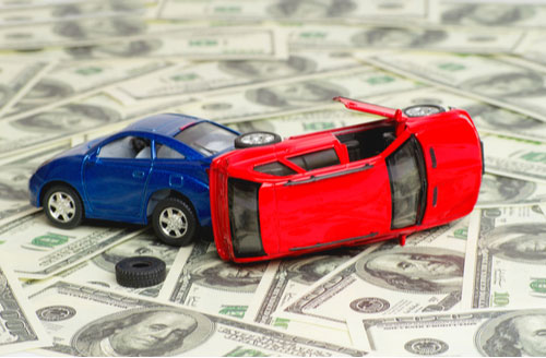 crashed toy cars and money, concept of car accident damages