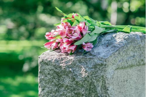 A grave with flowers, wrongful death caused by negligent security concept.
