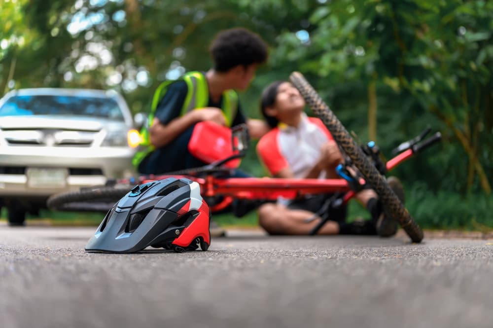 A bicyclist injured on the road after hit by a car