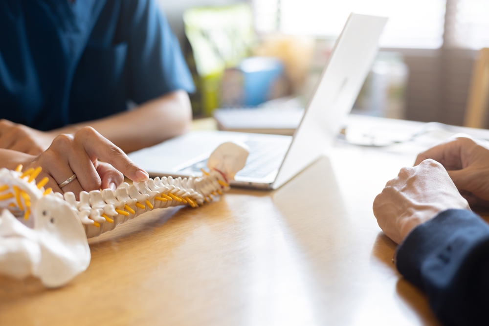 Medical professional explaining a spine model while discussing spinal cord injury impacts