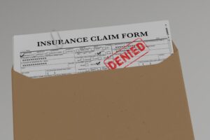 Document with denied stamp  put on the  wooden table - Concept of Insurance Claim denied