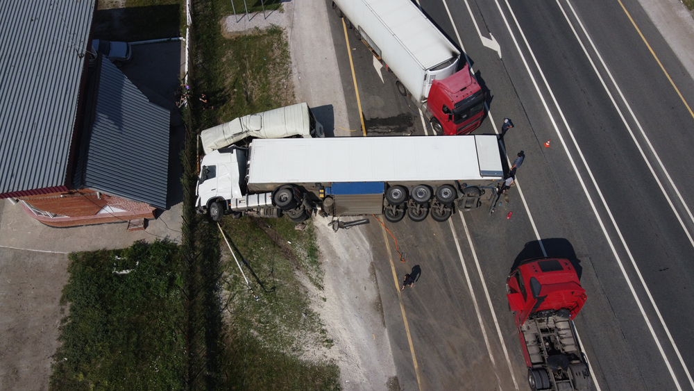 Aerial view of a jackknife truck accident blocking lanes on a highway.