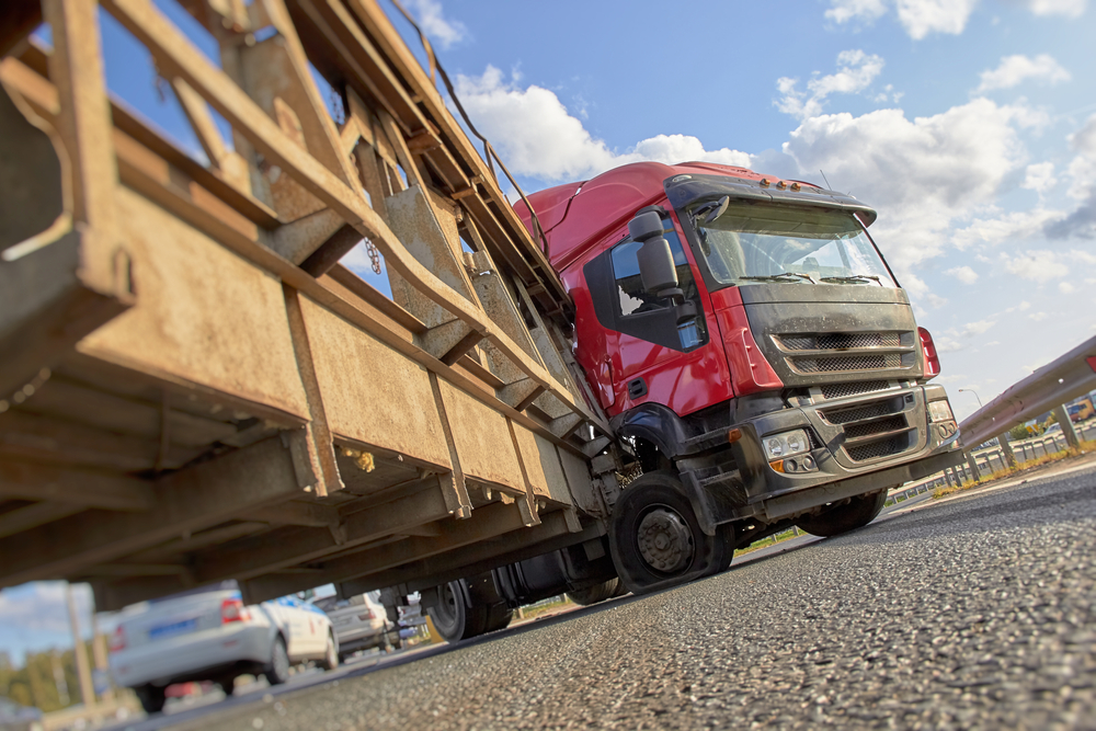 Semi-truck involved in a jackknife crash after colliding with a roadside barrier.